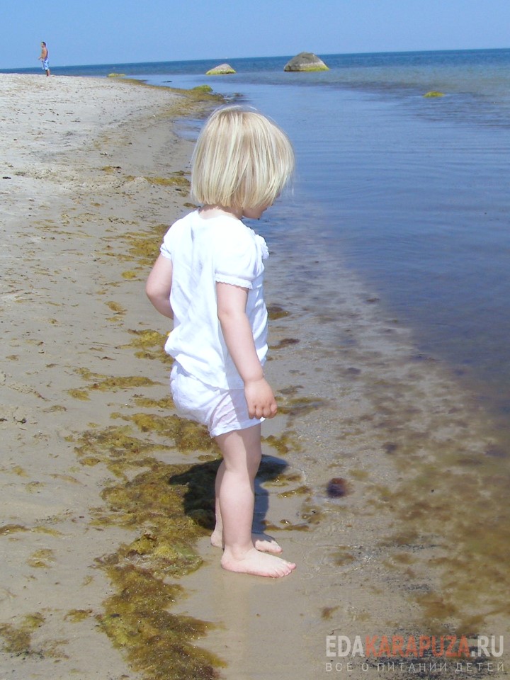Мальчик на берегу у воды на пляже