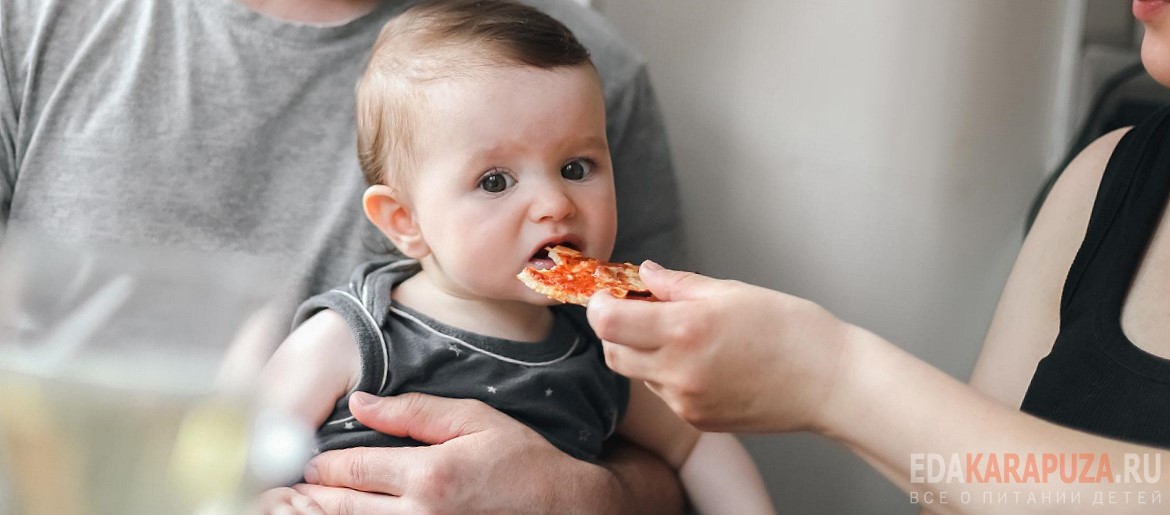 Маленький мальчик ест пиццу