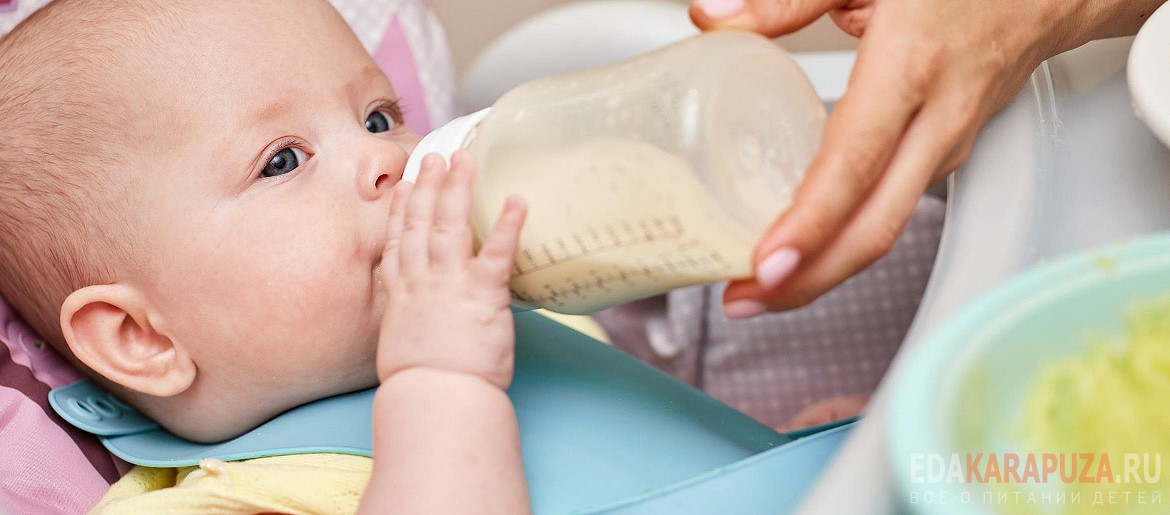 Малыш пьет молоко из бутылочки